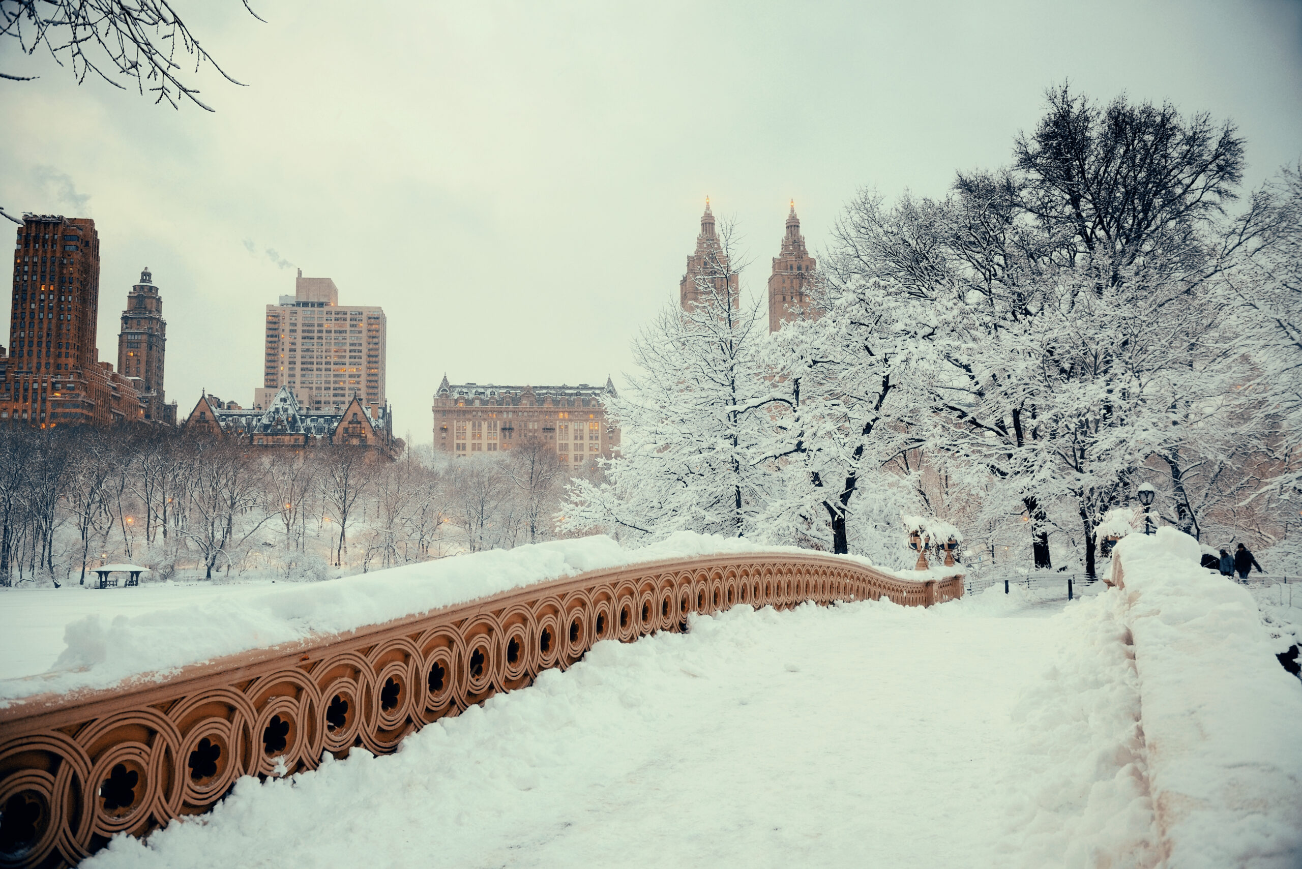 Central Park winter with skyscrapers and Bow Bridge in midtown Manhattan New York City
