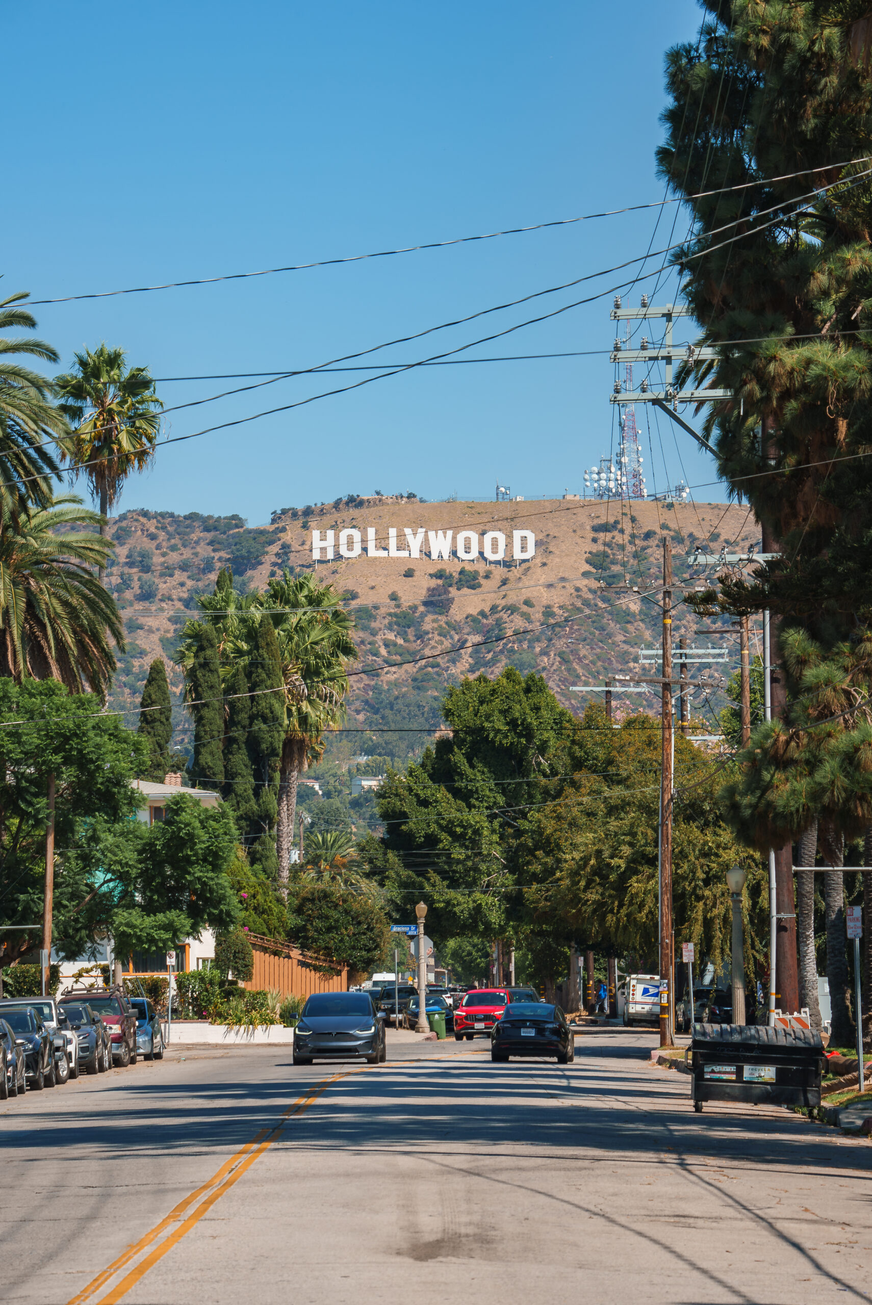 Hollywood sign viewed from palm-lined street in Los Angeles