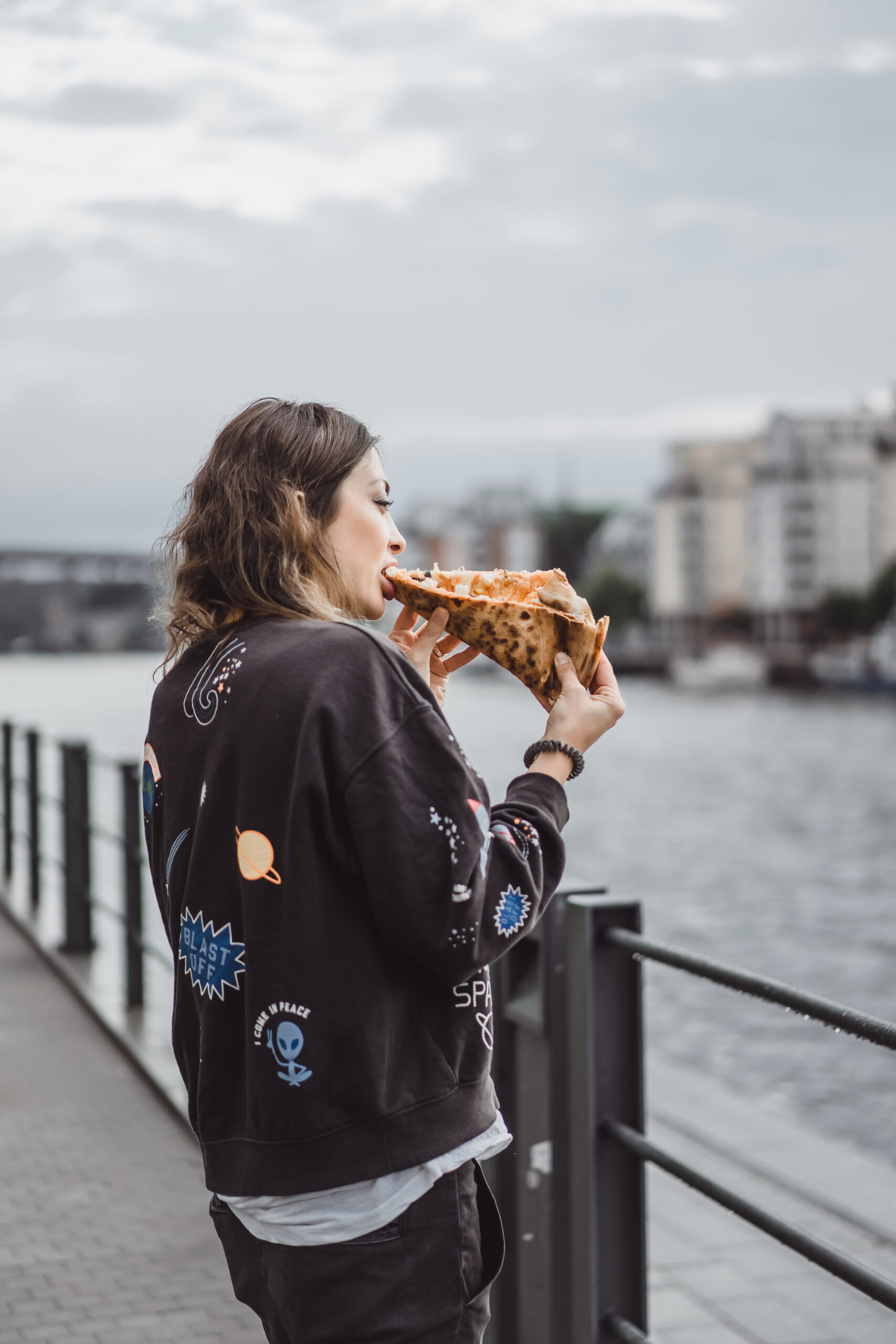 Woman eating pizza slice on New York City street